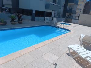 een zwembad aan de zijkant van een gebouw bij Apartamento Capão Novo in Capão da Canoa