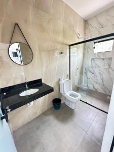 a bathroom with a toilet and a sink and a mirror at Pousada caminho das águas in Pirenópolis