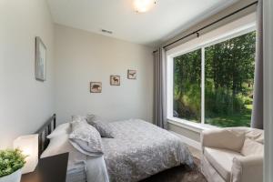 a bedroom with a bed and a large window at River & Garden View Suite of Kalama Oaks Lodge in Kelso