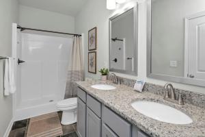 a bathroom with two sinks and a toilet at The Augusta Cottage WECO 3Br in West Columbia +10 photos