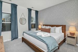 a bedroom with a large bed with blue curtains at The Augusta Cottage WECO 3Br in West Columbia