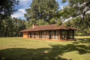 a small house in a field with trees at Puerto Mineral Hotel & Golf in Capioví