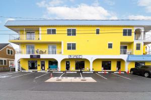 a yellow building with a car parked in a parking lot at 70 Steps to Beach Dewey Beach in Dewey Beach