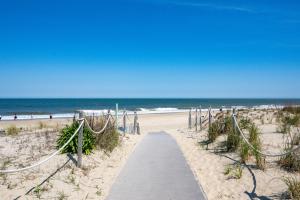 a sandy beach with a path leading to the beach at 70 Steps to Beach Dewey Beach in Dewey Beach