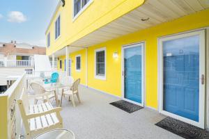 a yellow house with a patio with a table and chairs at 70 Steps to Beach Dewey Beach in Dewey Beach