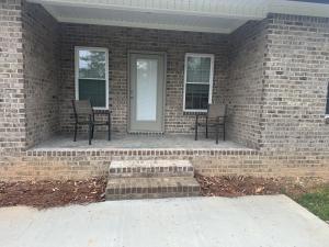 a brick house with two chairs on a porch at The Buford T Justice Suite in Lexington