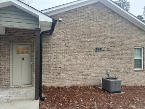a brick house with a white door and aphalt at The Buford T Justice Suite in Lexington +7 photos