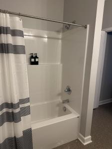 a bathroom with a tub and a shower curtain at The Buford T Justice Suite in Lexington