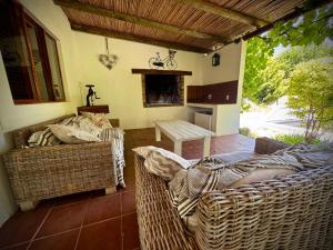 a patio with two wicker chairs and a table at Secluded Fynbos Retreat in Piketberg