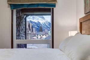キャンモアにあるRenovated Haven in Rockies with Hot Tub and Poolの窓から雪山が見える寝室