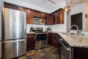 キャンモアにあるRenovated Haven in Rockies with Hot Tub and Poolの木製のキャビネットとステンレス製の冷蔵庫を備えたキッチン +28枚の写真