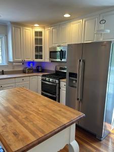 una cucina con mobili bianchi e un frigorifero in acciaio inossidabile di Back Creek, Winchester, VA a Winchester