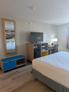 a hotel room with a bed and a flat screen tv at Days Inn & Suites by Wyndham Castle Rock in Castle Rock +37 photos