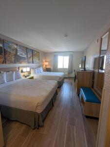 a hotel room with two beds and a television at Days Inn & Suites by Wyndham Castle Rock in Castle Rock