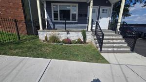 a house with a dog standing on the front porch at Attractive and Cozy Apartment - 4 bdrms 2 bths in Paterson