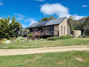 een huis met zonnepanelen op het dak bij Runway View Cottage at Touchdown Cottages in Jindabyne