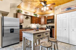 a kitchen with a refrigerator and a table with stools at Emerald Point, Lakefront with Gorgeous Views in McAlester