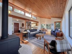 ein Wohnzimmer mit Sofa und Kamin in der Unterkunft Marielles Lookout - Your Oceanfront Escape Framed by Forest & Waves in Tofino