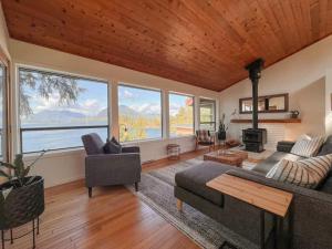 ein Wohnzimmer mit Sofa und Kamin in der Unterkunft Marielles Lookout - Your Oceanfront Escape Framed by Forest & Waves in Tofino + 25 Fotos