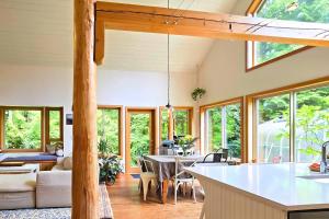 a kitchen and living room with a table and chairs at Cedar and Salt - By the beach with hot tub and sauna in Tofino