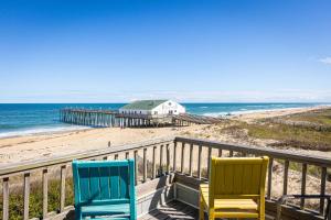 two colorful chairs sitting on a balcony overlooking the beach at Oceanfront Private Beach Access & Community Pool in Kitty Hawk Beach
