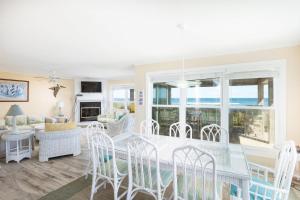 a dining room and living room with a table and chairs at Oceanfront Private Beach Access & Community Pool in Kitty Hawk Beach