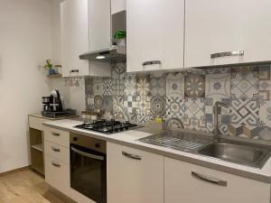 een keuken met een spoelbak en een fornuis bovenste oven bij Cujo Apartment in La Spezia