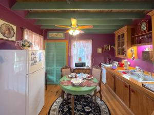 a kitchen with a table and a white refrigerator at Blue Crystal Hideaway BnB in Eureka Springs