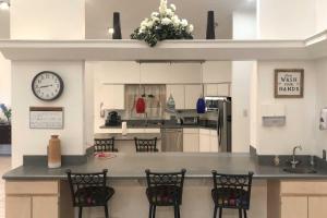 une cuisine avec un comptoir avec des chaises et une horloge dans l'établissement Pet-Friendly Dover Retreat with Yard and Pool Table, à Dover