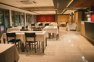 a dining room with white tables and chairs at Puerto Mineral Hotel & Golf in Capioví