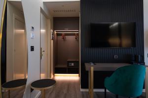a room with a table and two chairs and a television at boutique hotel gambero rosso in Marina di Gioiosa Ionica