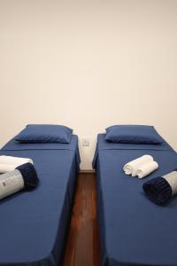 Studio Privativo 3 min Centro para 4 pessoas com 2 quartos ar condicionado في أبرلانديا: سريرين في غرفة ذات أغطية زرقاء ووسائد بيضاء