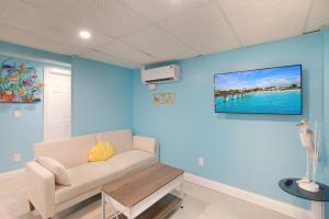 a living room with a couch and a tv on the wall at Sand Dollar Suite by Sun Palace Vacations in Fort Myers Beach