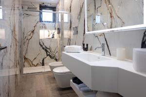 a white bathroom with a sink and a toilet at boutique hotel gambero rosso in Marina di Gioiosa Ionica