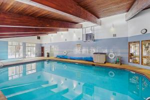 a large swimming pool with blue water in a house at Coziest Condo in Winter Park