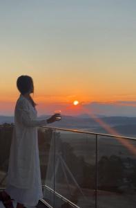 a woman standing on the edge of a balcony watching the sunset at Monte zone Zabljak in Žabljak