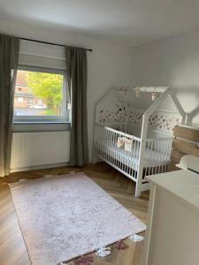 Modernes Haus mit Garten in Windberg, ruhig & zentral في مونشنغلادباخ: غرفة طفل مع سرير ونافذة
