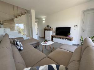 een woonkamer met een bank en een tv bij Il Casalone in Ponte a Tressa