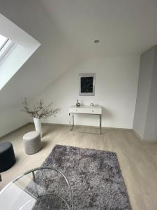 ein weißes Zimmer mit einem Tisch und einem Teppich in der Unterkunft 2 Zimmer-Wohnung ruhig modern zentrumsnah in Abensberg