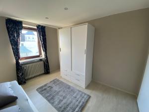ein Wohnzimmer mit einem weißen Schrank und einem Fenster in der Unterkunft 2 Zimmer-Wohnung ruhig modern zentrumsnah in Abensberg + 10 Fotos