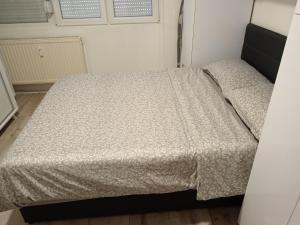 Dormitorio pequeño con cama con edredón en Apartman Centar 2, en Šabac