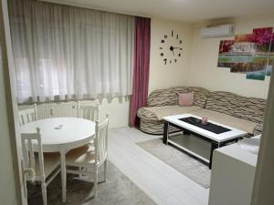 Una pequeña sala de estar con una mesa y un sofá. en Apartman Centar 2, en Šabac 3 fotos más