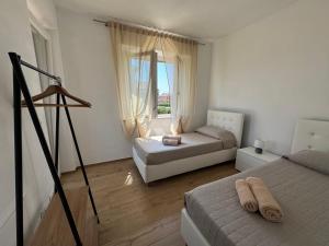 een slaapkamer met twee bedden en een raam bij Il Casalone in Ponte a Tressa