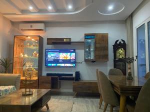 a living room with a flat screen tv and a table at Luxe & Sérénité Sahloul 4 in Sousse