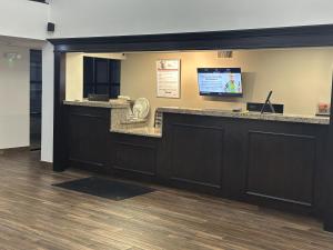 a lobby with a bar with a tv on the wall at Red Roof Inn & Suites Middleborough in Middleboro