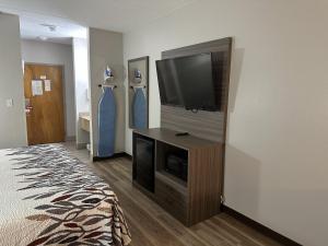 a hotel room with a flat screen tv on a wall at Red Roof Inn & Suites Middleborough in Middleboro