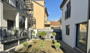 a courtyard of a building with trees and plants at Apartmani Bjelovar - Centar 4 in Bjelovar