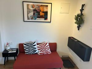 a living room with a red couch and a tv at Apartmani Bjelovar - Centar 4 in Bjelovar