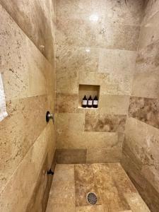 a bathroom with a shower with three bottles of wine at Kasa Nikte in Tulum +85 photos