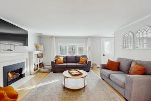 un soggiorno con due divani e un camino di Portview Paradise a Harwich Port